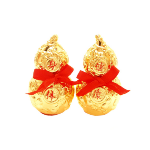 A pair of golden Wu Lou gourds adorned with intricate engravings and red Antahkarana symbols, each tied with a bright red ribbon. The Wu Lou, known for its symbolic representation of health and longevity in Feng Shui, is designed with ornate patterns that enhance its auspicious appearance. The vibrant gold color and red accents make these decorative items perfect for attracting positive energy and protection.